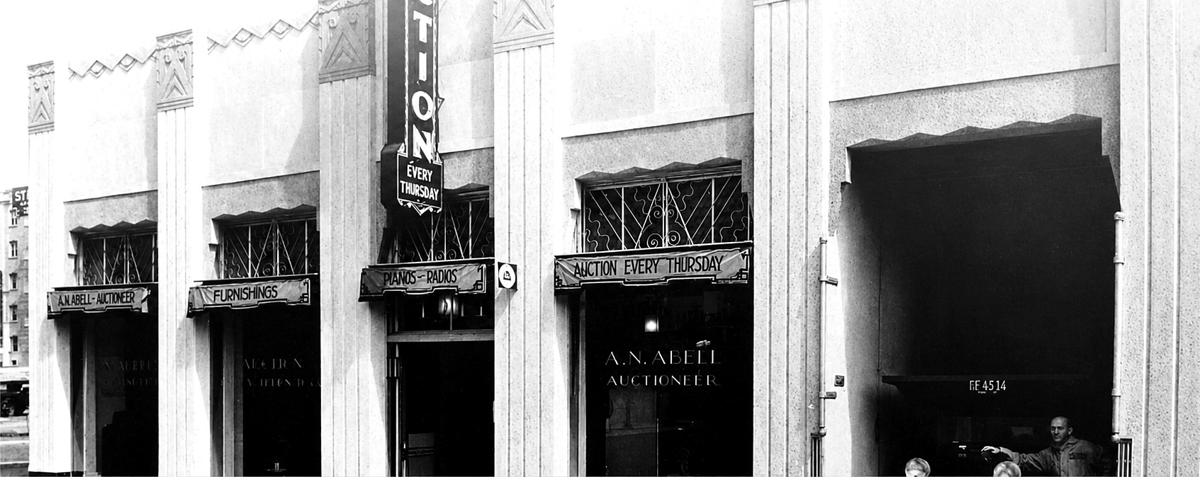 The A. N. Abell Auction Company storefront, the window lettered A. N. Abell, Auctioneer and the awnings reading Furnishings, Pianos and Radios, and Auction Every Thursday