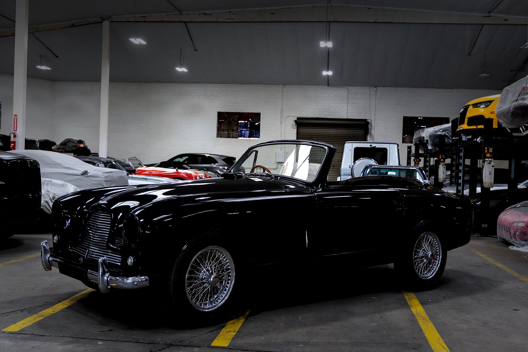 A car in the Abell warehouse among covered and stored automobiles