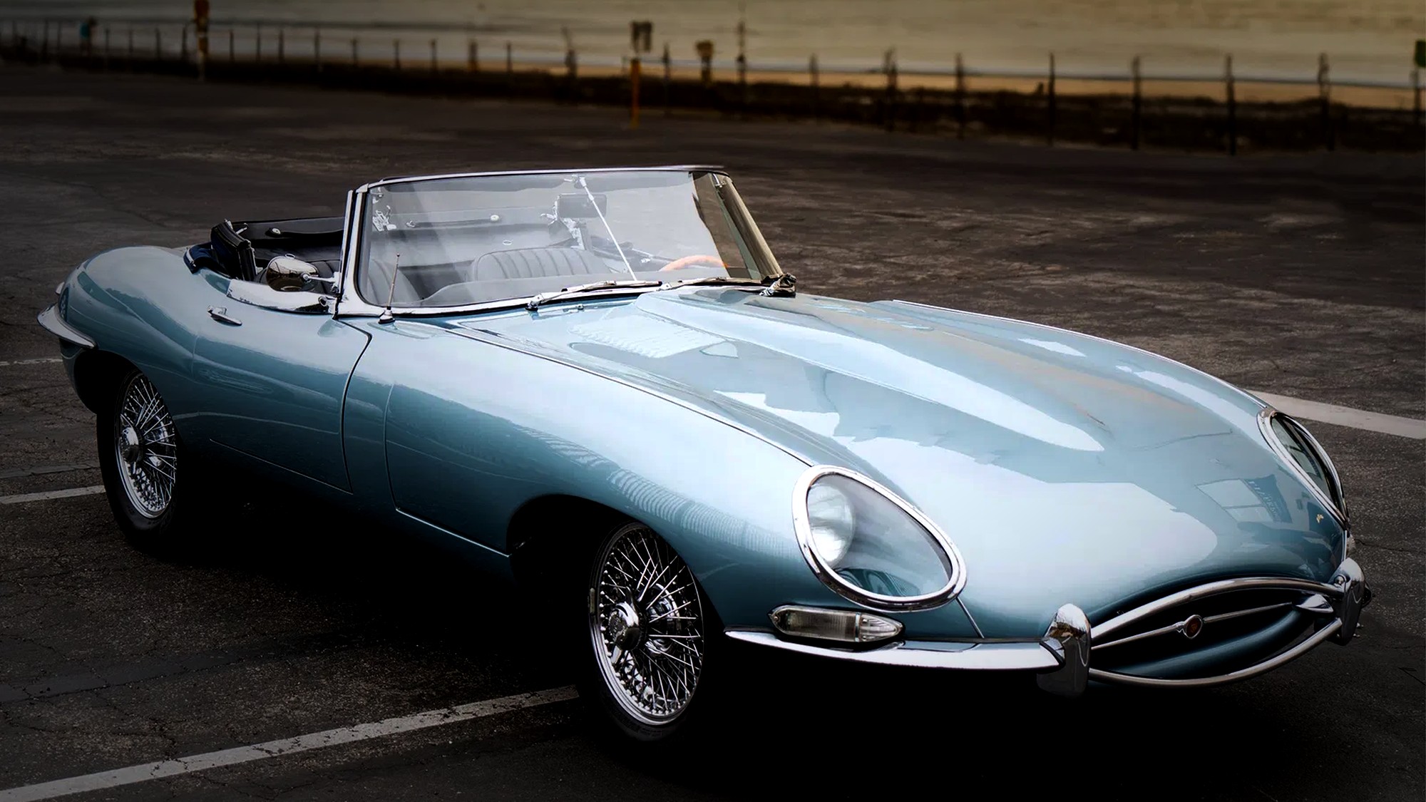 A Jaguar E-Type roadster photographed at dusk on the Southern California coast