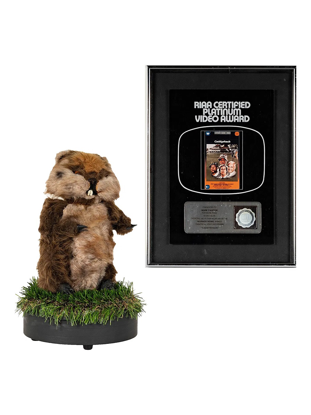 The Caddyshack gopher puppet on a turf base, beside a framed RIAA platinum video award for Caddyshack presented to Mark Canton